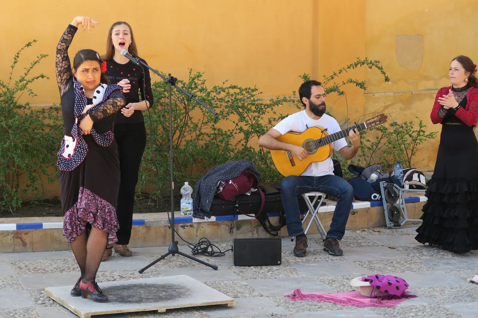 A flamenco dancer in a polka-dot shawl, a singer, a seated guitarist and a clapping palmera perform in a courtyard in Seville, not at the Alicante tablao